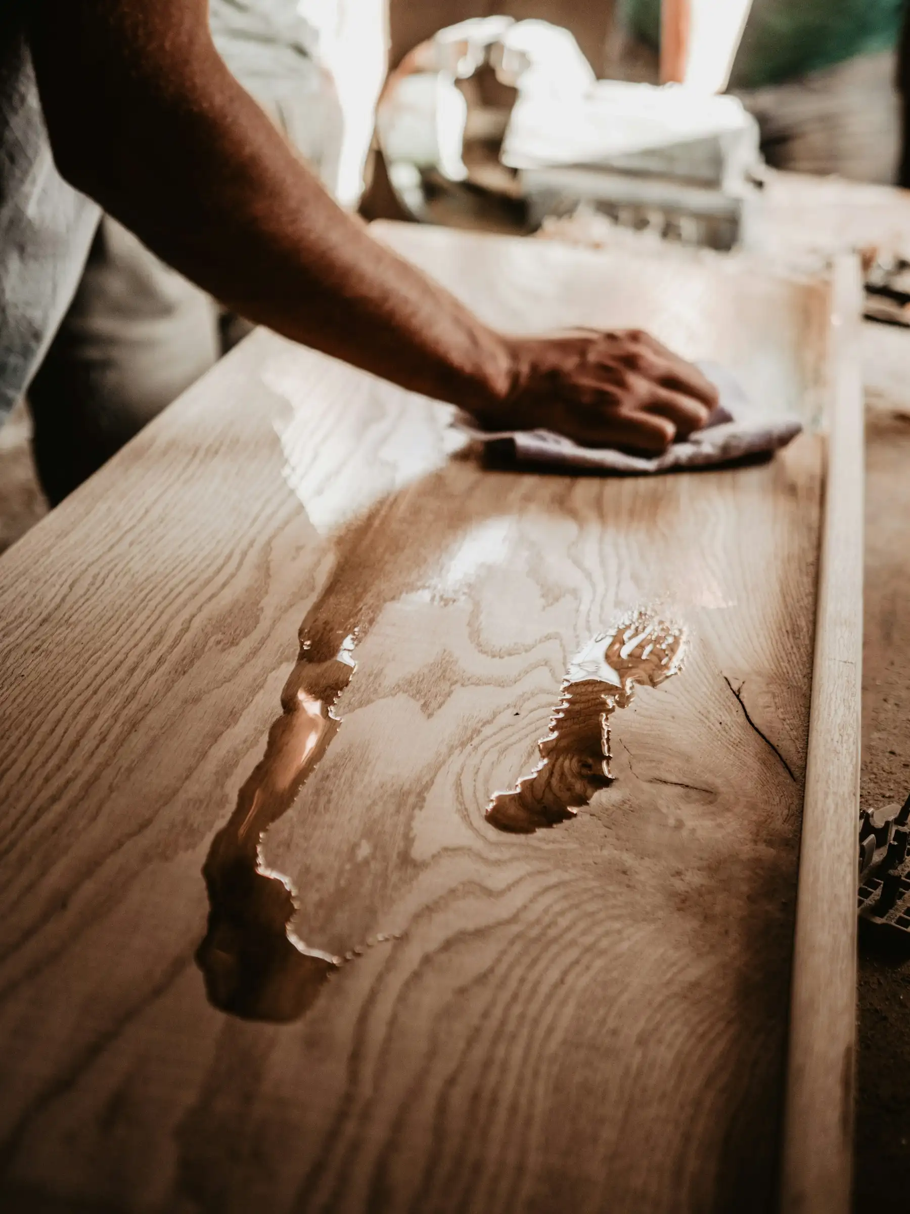 Application d’huile au chiffon sur un plateau en bois massif dont le fil ressort