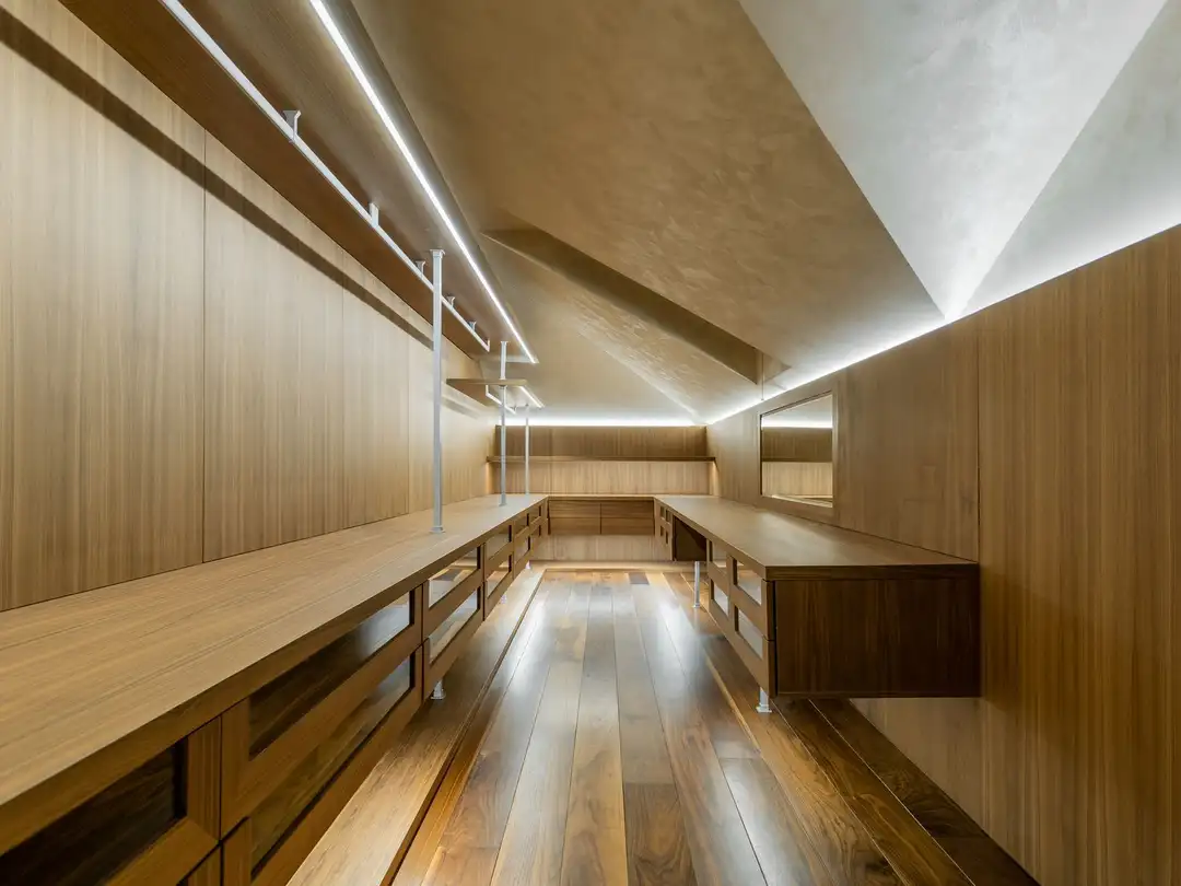 Dressing sous pente entièrement en bois, tringles éclairées et meubles bas sous les rampants
