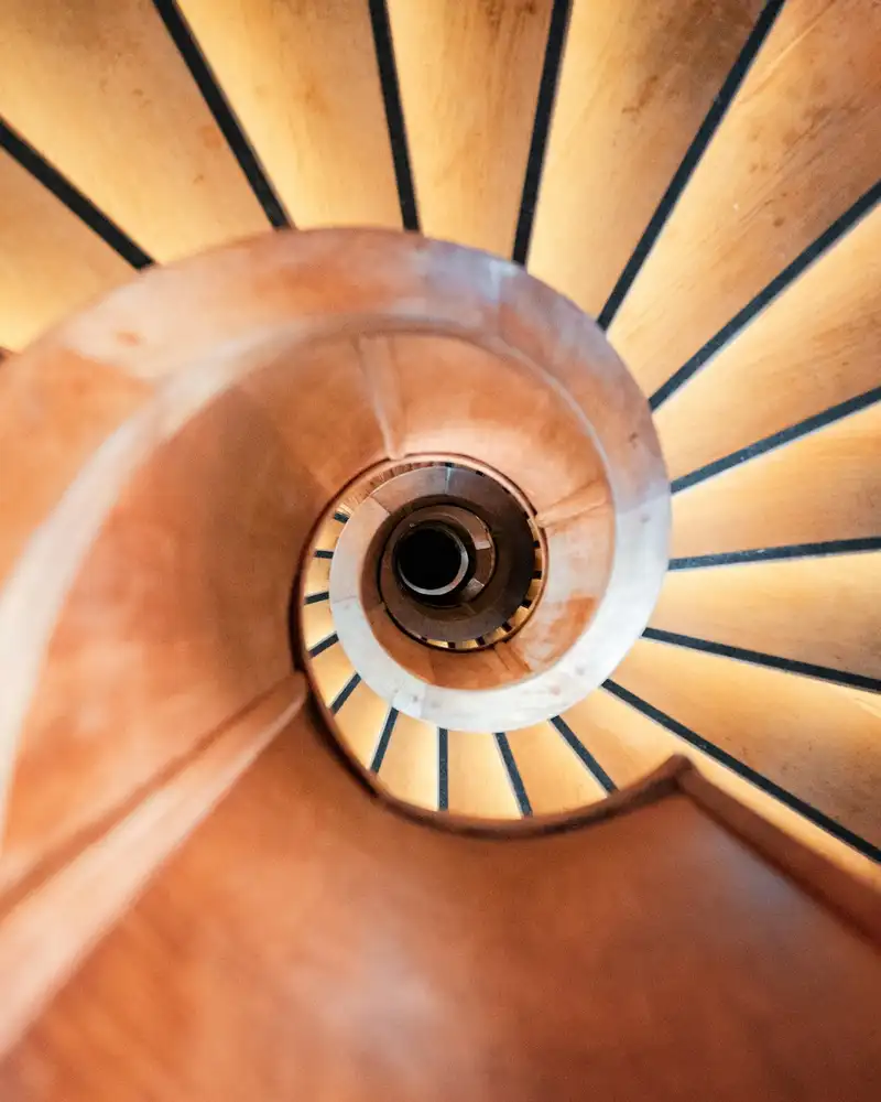 Holzwendeltreppe von oben, gebogener Handlauf und radial angeordnete Stufen