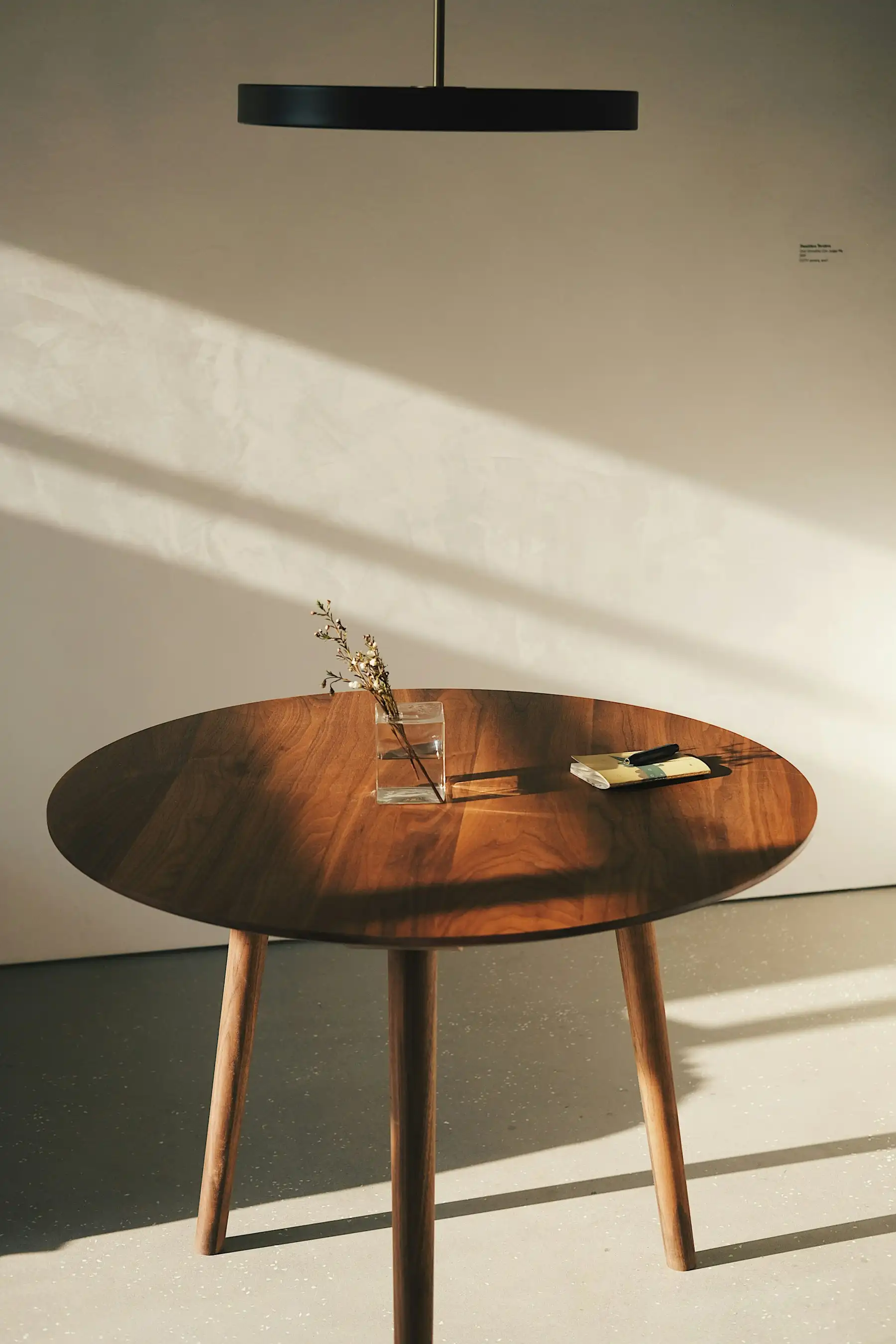 Runder Tisch aus Nussbaum mit konischen Beinen im Sonnenlicht