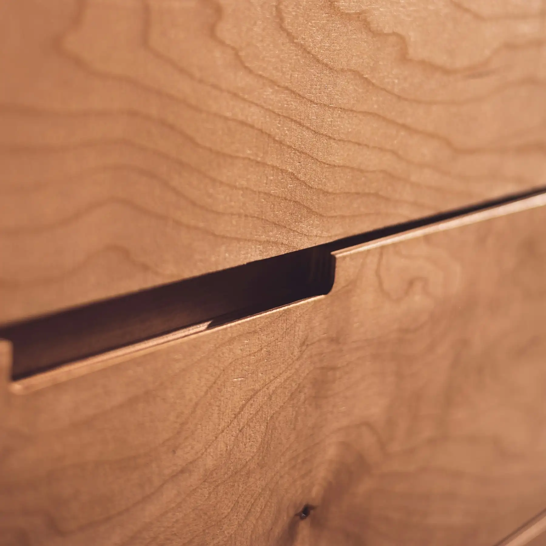Detail einer Holzschublade mit in die Kante gefräster Griffmulde