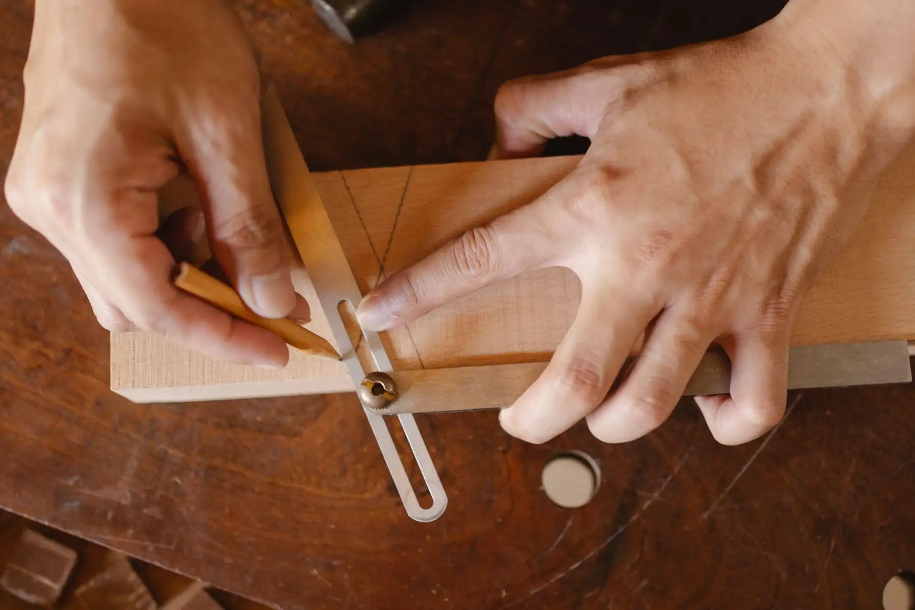 Traçage au crayon d’un angle à la fausse équerre sur une pièce de bois clair